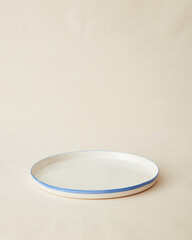 Handmade ceramic plate on beige background.