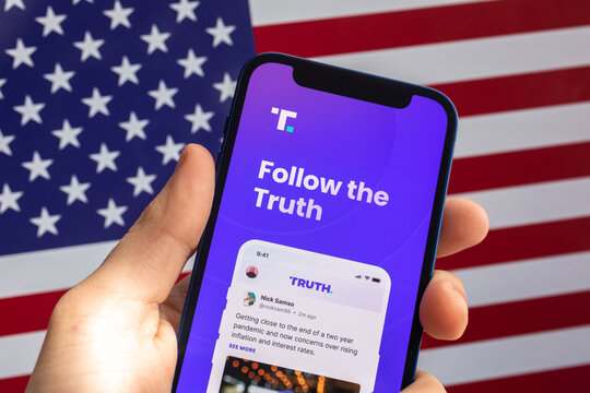 Truth Social logo displayed on a smartphone against USA flag background. Social media app by Trump Media