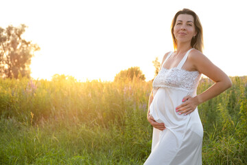 Fototapeta na wymiar Future mom expecting baby. Copy space. Pregnancy, maternity, expectation concept. beautiful woman in white nightie with big tummy outside.