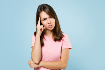 Young sad pensive minded puzzled caucasian woman 20s wearing pink t-shirt look camera prop up head forehead isolated on pastel plain light blue background studio portrait. People lifestyle concept