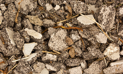Different gray stones lie on the ground, stone background.
