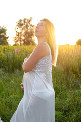 Future mom expecting baby. Copy space. Pregnancy, maternity, expectation concept. beautiful woman in white nightie with big tummy outside.