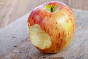 red ripe apple on a wooden chopping board
