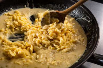 Eiernockerln mit Käse in Pfanne