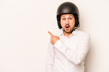 Hispanic business man going to work with motorcycle isolated on white background pointing to the...