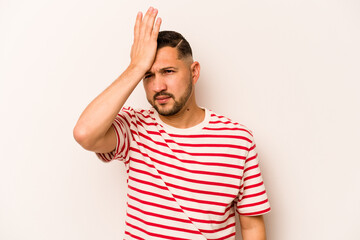Young hispanic man isolated on white background forgetting something, slapping forehead with palm...