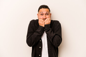 Young hispanic man isolated on white background biting fingernails, nervous and very anxious.