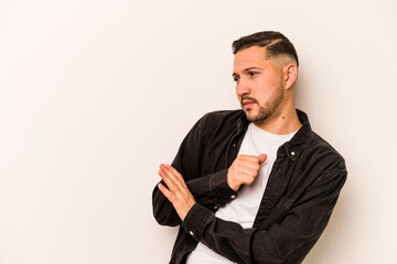 Young hispanic man isolated on white background confused, feels doubtful and unsure.