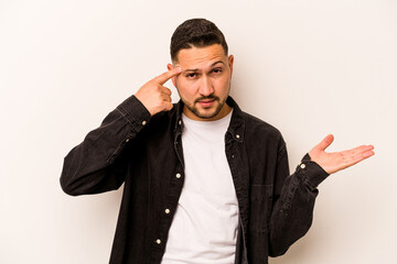 Young hispanic man isolated on white background showing a disappointment gesture with forefinger.