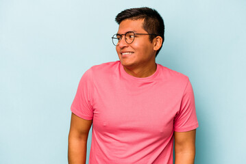 Fototapeta premium Young hispanic man isolated on blue background laughs and closes eyes, feels relaxed and happy.