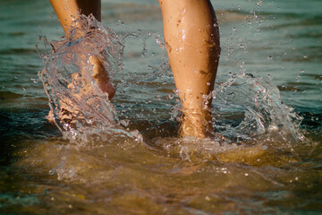 Legs of the girl walking among the small waves of the sea.
Legs of a girl running to the ocean on a sandy beach.
Close-up Girl's Legs In Shallow Water.