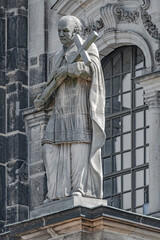 Old statute of priest with cross at Cathedral of Holy Trinity, historical downtown and city center of Dresden, Germany.
