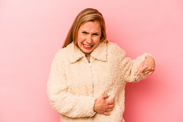 Young caucasian woman isolated on pink background having a liver pain, stomach ache.