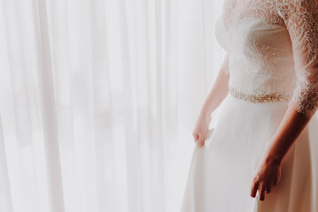 An unrecognizable bride woman in her wedding dress, with white copy space and added film grain.
