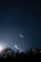 Amazing starry night with the light of a moon on the top of the hill in Carpathian mountains
