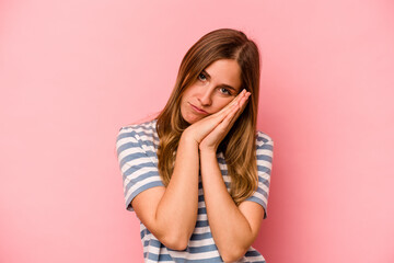 Young caucasian woman isolated on pink background yawning showing a tired gesture covering mouth with hand.