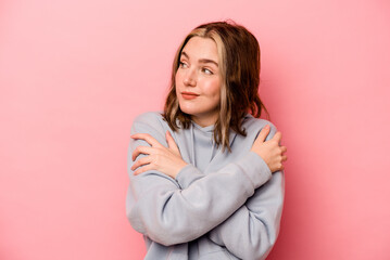 Young caucasian woman isolated on pink background hugs, smiling carefree and happy.