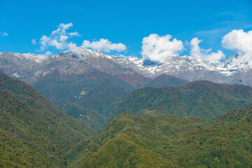 Beautiful green mountains with snowy peaks on a sunny day. Beautiful mountain landscape