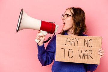 Young caucasian woman holding no war placard isolated on pink background