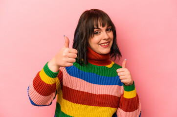 Young caucasian woman isolated on pink background raising both thumbs up, smiling and confident.