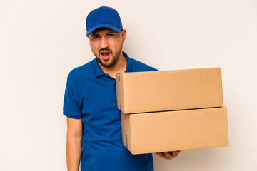 Hispanic delivery man isolated on white background screaming very angry and aggressive.