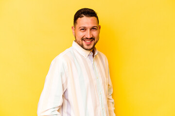 Young hispanic man isolated on yellow background confident keeping hands on hips.