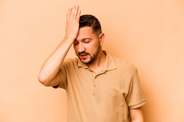 Young hispanic man isolated on beige background forgetting something, slapping forehead with palm and closing eyes.