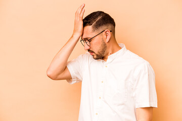 Young hispanic man isolated on beige background forgetting something, slapping forehead with palm and closing eyes.