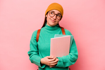 Young student caucasian woman isolated on pink background dreaming of achieving goals and purposes