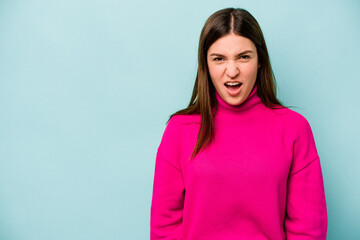 Fototapeta premium Young caucasian woman isolated on blue background shouting very angry, rage concept, frustrated.