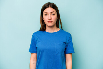 Young caucasian woman isolated on blue background sad, serious face, feeling miserable and displeased.