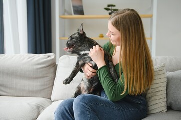 Female owner playing with joyful dog at home. Playing with dog concept