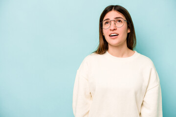 Fototapeta premium Young caucasian woman isolated on blue background shouting very angry, rage concept, frustrated.