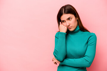 Young caucasian woman isolated on pink background who feels sad and pensive, looking at copy space.