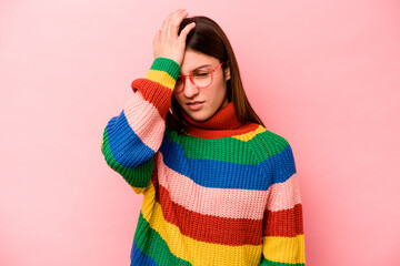 Young caucasian woman isolated on pink background forgetting something, slapping forehead with palm...