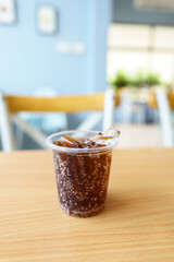 sparking water soda or cola in the plastic glass on the table