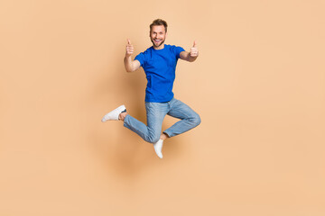 Fototapeta na wymiar Full body photo of excited cheerful man two hands demonstrate thumb up isolated on beige color background