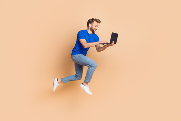 Full size profile side photo of young energetic guy type chat laptop jump up agent isolated over...