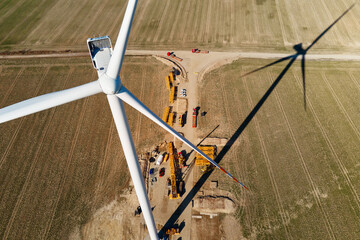 Installing new wind generator, Windmill turbine maintenance, Construction site with cranes for assembling windmill tower, Wind power and renewable energy - obrazy, fototapety, plakaty