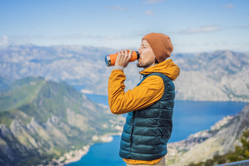 Man tourist enjoys the view of Kotor. Montenegro. Bay of Kotor, Gulf of Kotor, Boka Kotorska and walled old city. Travel to Montenegro concept. Fortifications of Kotor is on UNESCO World Heritage List