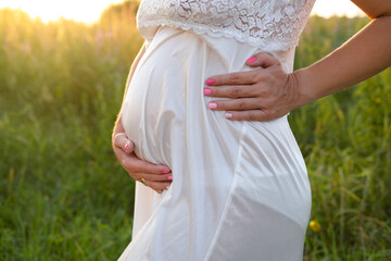 Fototapeta na wymiar close up of cute Pregnant tummy on nature background. motherhood concept.