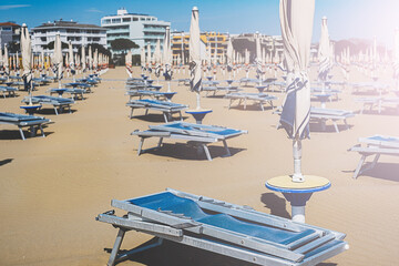 Umbrellas and sunbeds on the beach in Italy. The beach season is ready for opening.