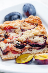 piece of plum pie with plums around
