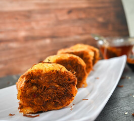 Indonesian snack, Roti gulung abon ikan tuna or Shredded tuna roll on a white folding plate.