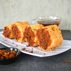 Indonesian snack, Roti gulung abon ikan tuna or Shredded tuna roll on a white folding plate.