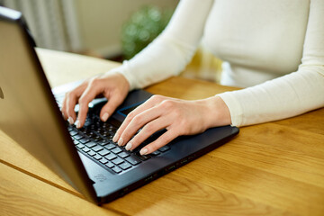 Unrecognizable hand Freelancer woman working with laptop on the table at home, female typing on the computer for remote working