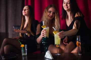 Women have fun and drinking cocktails with fruits