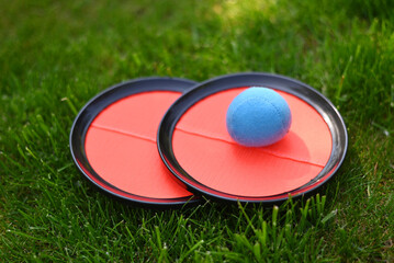 Velcro Catch Ball. children's summer game  on green garden grass background