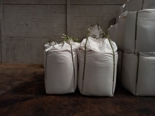 Large jumbo hemp sack White, packed with chemical fertilizer, rice, sugar, placed on a wooden pallet waiting to be delivered to the customer