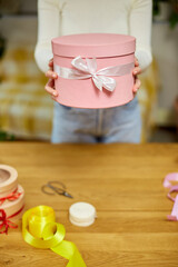Female hands holding, give pink gift with white ribbon, present box,